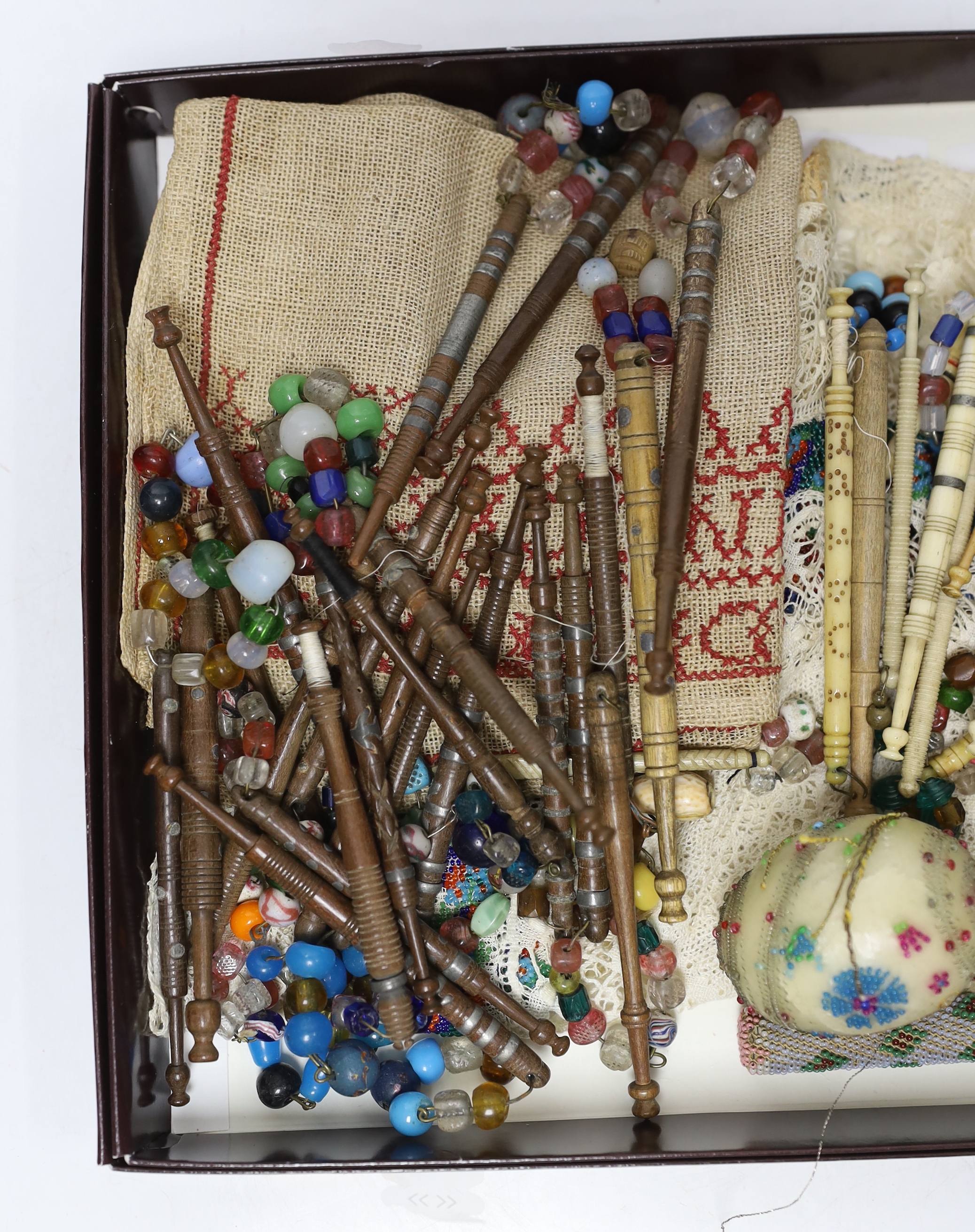 Sewing items: including a collection of bone and wooden lace maker’s bobbins, a beadworked needlecase, an egg and beadworked mats, etc.